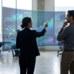 Deux professionnels analysent des données sur un écran holographique en bureau, symbolisant l'IA et l'innovation B2B.